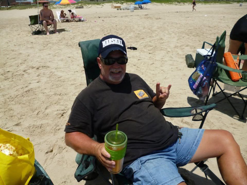 At the beach, cap and sunglasses, relaxing in a chair